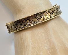 This is a Victorian Revival, hinged bangle from the. 1930's - 40's. I love this bracelet both in style and condition! It is 12K gold filled.  This has a beautiful etched and textured pattern to it. It features a floral pattern.  The background has a texture to make the flower stand out. It features a slide clasp that is in perfect working order with an attached safety latch for extra protection. Beautiful piece on its own or stack it with more for a statement look.  If you want a pair, I have a second one listed!  Condition: Very good vintage condition, vintage patina consistent with age - I do not see any wear! Measurements: 0.43" or 10.71 mm wide; inside measurement 7" around Weight: 17.2 grams Markings: 1/20 12KTGF and what looks like 3 initials that I cannot make out Please examine pho Vintage Adjustable Hinged Bracelets, Vintage Adjustable Hinged Bracelet, Vintage Hinged Bangle Bracelet, Vintage Hinged Bangle For Formal Occasions, Adjustable Vintage Bangle, Vintage Hinged Cuff Bracelet, Vintage Hinged Bangle, Adjustable Vintage Bangle With Etched Details, Vintage Adjustable Hinged Cuff Bracelet