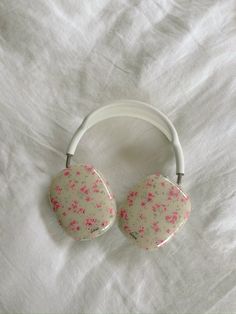 a pair of headphones laying on top of a white sheet with pink sprinkles