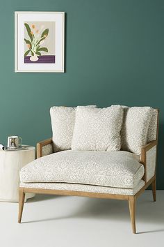 a white couch sitting next to a green wall