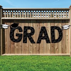 graduation banner with the word grad hanging from it's side in front of a fence