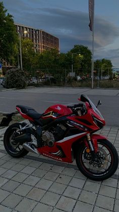 a red motorcycle is parked on the side of the road