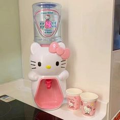 a hello kitty water dispenser and cups on a counter