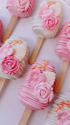 pink and white cupcakes on wooden sticks decorated with flowers are ready to be eaten