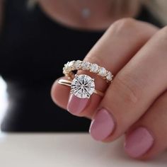 a woman's hand holding a diamond ring