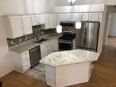 an empty kitchen with white cabinets and granite counter tops