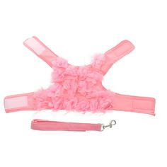 a pink dog harness with ruffles and a leash attached to the front of it