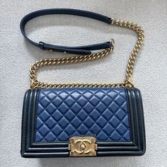 Authentic Chanel Lambskin Two-Color Medium Boy Flap In Navy & Black. Linear Quilted Border. The Bag Features A Matte, Distressed Gold Chain-Link Shoulder Strap With A Navy Leather Shoulder Pad, And A Gold Boy Cc Push Lock On The Front. This Opens The Bag To A Black Navy Interior With A Patch Pocket. I Haven’t Posted An Item In A While, But I Am Making Room In My Collection. As You Can See From My Sales, I Have A Consistent 5-Star Rating For Authenticity And Service. I Only Sell Items From My Personal Collection And I Am Extremely Careful With My Things. I Am Including Photos That Show Any Wear, But Please Rest Assured That The Item In-Person Does Not Show The Wear As Obviously In The Wa Designer Textured Leather Bag For Everyday Luxury, Designer Everyday Luxury Textured Leather Bag, Everyday Luxury Textured Leather Rectangular Bag, Designer Square Bag In Textured Leather, Designer Square Bags In Textured Leather, Designer Textured Leather Square Bags, Designer Square Textured Leather Bag, Luxe Rectangular Shoulder Bag For Shopping, Navy Interior