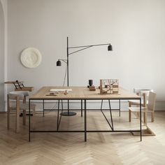 a wooden table sitting on top of a hard wood floor next to a white wall