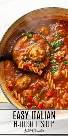 a skillet filled with pasta and meatballs in tomato sauce that is being stirred by a ladle