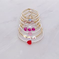 All of our bracelets are handmade in Hoboken, NJ, a little town which is near and dear to our hearts. This beautiful Swarovski heart bracelet is completely customizable - chose a single crystal heart or three. Also choose from 8 colors: red, fuchsia, rose, dusty lilac, mermaid, unicorn, clear, and silk. One inch of extra chain lets you adjust the bracelet to your preference. All items are hand-made in the USA in a smoke-free studio, and most importantly, they're made with OurWholeHeart❤︎ ------- Adjustable Crystal Bracelet With Heart Beads For Gift, Adjustable Heart Beads Crystal Bracelet Gift, Adjustable Heart-shaped Crystal Bracelet Gift, Silver Beaded Crystal Bracelet For Valentine's Day, Valentine's Day Silver Beaded Crystal Bracelet, Adjustable Faceted Bead Jewelry For Valentine's Day, Valentine's Day Adjustable Bracelets With Faceted Beads, Dainty Heart Charm Bracelet With Round Beads, Adjustable Crystal Heart Bracelet With Charm