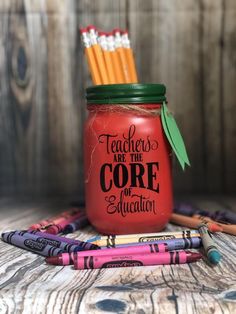 there is a red mason jar with some pencils in it and the words teachers are the core of education