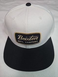 Elevate your streetwear game with this Brixton MFG. Company Ball Cap Snapback. The two-tone design in black and brown, along with the one-size-fits-most feature, make it a versatile addition to any wardrobe. Made from a blend of wool and acrylic materials, this hat is perfect for all-day wear. It's a must-have for men who want to add a touch of style to their outfit. Whether you're running errands or hitting the gym, this snapback hat is the perfect accessory to complete your look. Ball Cap, Snapback Hat, The Gym, Snapback Hats, Running Errands, Black And Brown, Two Tone, Accessories Hats, Two By Two