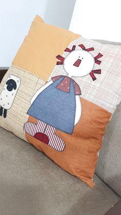 a decorative pillow on the back of a couch with an animal and sheep patchwork design