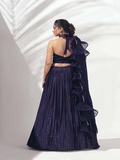 A three-piece Purple halter lehenga set from the Suruchi Parakh collection. This gorgeous georgette crepe lehenga is paired with a zardosi handwork satin blouse. The outfit is completed with a matching soft organza dupatta. The halter blouse has a feather neckline with a back tie-up. And, the dupatta has a beautiful touch of ruffle and zardozi handwork hemline. Evening Georgette Anarkali Set With Cutdana, Evening Anarkali Set With Cutdana On Georgette, Evening Silk Lehenga With Mirror Work, Silk Lehenga With Mirror Work For Evening, Evening Georgette Dresses With Pallu, Evening Sharara With Unstitched Blouse In Georgette, Anarkali Lehenga With Cutdana For Evening, Evening Silk Lehenga With Sheer Dupatta, Floor-length Satin Lehenga For Party