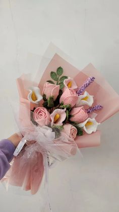 a hand holding a bouquet of pink and white flowers