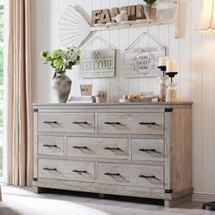 a dresser in a living room with flowers on top