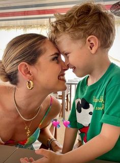 a woman kissing a young boy on the cheek