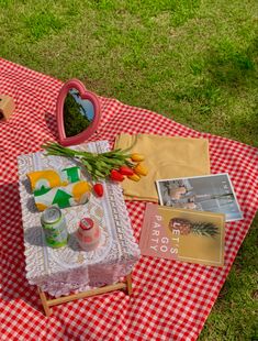 a picnic table with food and drink on it in the middle of an open field