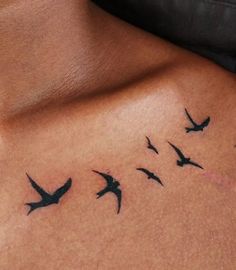 a woman's stomach with birds flying around her tattoo design on the side of her chest