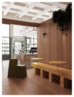 a room with wooden floors and tables in the center, along with plants hanging from the ceiling