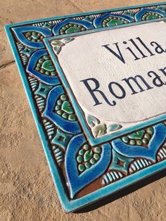 a blue and green tile with the words villa roma written on it in black lettering