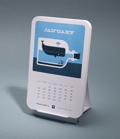 a desk calendar with an image of a boat in the water on it's side