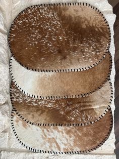 two brown and white rugs sitting on top of a wooden floor next to each other