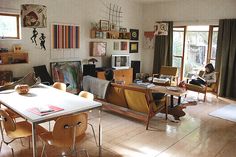 a living room filled with lots of furniture and decor on top of hard wood flooring