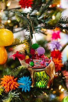 an ornament hanging from the christmas tree with other ornaments on it's branches