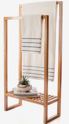 a towel rack with two towels and a potted plant on it in front of a white background