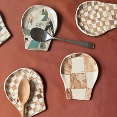 four pieces of pottery with spoons and plates on top of each other, one has a checkerboard design