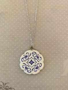 "Portugal inspired blue and white ceramic azulejo tile look necklace.  Silver tone edging.   Pendant measures 1 3/8\" in diameter and is on an 18\" chain. ★ Want to see more?  Please visit my shop at: https://www.etsy.com/shop/DesignsByPeg" Detailed Ceramics, Ceramic Jewelry Handmade Novica, Infinite Jewelry, Pottery Jewelry Necklaces, Ceramic Locket, Portugal Jewelry, Blue And White Necklace, Delft Clay Casting Jewellery, Porcelain Necklace Ceramics