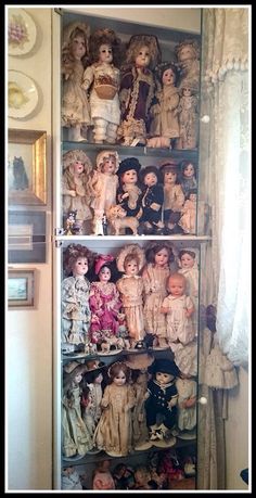 there are many dolls on the shelves in this room