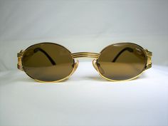 "An intoxicating amalgam of original atypical design and top optical technology, produced by prestigious yet elusive \"Castellani-Italy \", a genuine Gold Bonanza, much sought after by collectors and wearers alike. Produced in the 1990's by legendary designer Danilo Castellani-Italy, a rare if not unique pair of sunspecs. Hand made super heavy Gold plated metal alloy frame, sumptuously embellished with Platinum plated sculptural Egyptian motifs (King Tut's head), complemented with jet black acet Gold Oval Sunglasses With Mirrored Lenses, Gold Oval Sunglasses With Gradient Lenses, Vintage Gold Sunglasses With Polarized Lenses, Vintage Gold Sunglasses With Gradient Lenses, Vintage Oval Sunglasses For Formal Occasions, Gold Oval Sunglasses For Formal Occasions, Formal Gold Oval Sunglasses, Vintage Gold Sunglasses For Formal Occasion, Egyptian Motifs