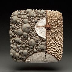 a piece of art made out of rocks and stones with circles on it, including an eyeball