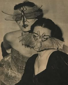 an old photo of two women with masks on their faces