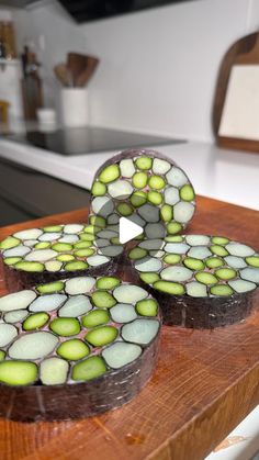 three pieces of cake sitting on top of a wooden cutting board with green and white frosting