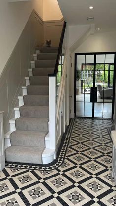 a staircase with black and white tiles on the floor