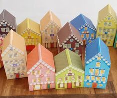 small houses are lined up on a wooden table