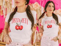 "Looking for a sorority tee that's on trend? 🫶🏻 This Cherry Bomb Baby Tee is the answer! Whether you're giving this tee as a gift or treating yourself with something new, you'll be obsessed with this trendy sorority crop top! 🌊 YOU'LL LOVE THIS STYLE 🌊 Looking for a sorority basic that's on trend? The white baby tee is the perfect choice! Made with super soft and breathable fabric, this crop top features thicker seams on the collar and sleeves for a more quality feel. The true-to-size form-fitting design is perfect for showing off your figure. But if you prefer a looser look, don't hesitate to size up.  🌊 YOU'LL LOVE THIS DESIGN 🌊 Its the cherry on top! This bright cherry design is perfect for a fun and trendy tee. Featuring a bright pair of cherries and your sorority name arched abo Preppy Graphic Print Crew Neck Top, Preppy Crew Neck Top With Graphic Print, Preppy White T-shirt For Spring, School Spirit T-shirt For Game Day In Spring, Pink Sorority T-shirt For Summer, Sorority Cotton T-shirt For Spring, Sorority Style Cotton T-shirt For Spring, Spring Sorority Cotton T-shirt, Pink Sorority T-shirt For Spring