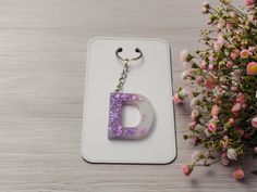 the letter d is made out of plastic and has purple sprinkles on it