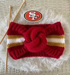 a knitted headband with a san francisco logo on it and two knitting needles