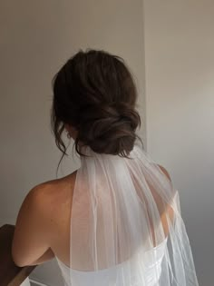 the back of a woman wearing a white veil