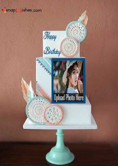 a birthday card on top of a cake decorated with doily, feathers and photos