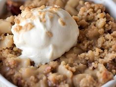 a close up of a bowl of food with ice cream on top and crumbled topping