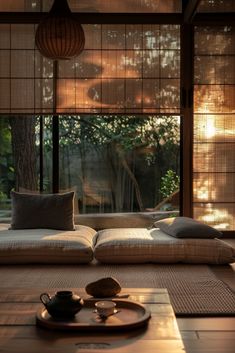 a living room filled with lots of furniture next to a large glass window covered in bamboo blinds