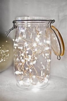 a mason jar filled with fairy lights on top of a table