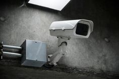 a security camera sitting on the side of a wall next to a box and light