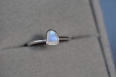 A stunning sterling silver moonstone ring with blue tones of color. The moonstone bezel ring has brilliant flash and is this ring is perfect for an everyday simple ring or stacked with other rings. Size :  choose from dropdown Material : Sterling Silver Gemstones : Rainbow Moonstone See other items from my store here https://www.etsy.com/shop/GalantaJewels?ref=hdr_shop_menu Packaging : All products purchased from us come in a gift box. If you need to include a message, kindly leave us a note whe Minimalist Moonstone Stackable Rings As Gifts, Adjustable Minimalist Moonstone Ring In Sterling Silver, Minimalist Adjustable Sterling Silver Moonstone Ring, Minimalist Sterling Silver Moonstone Promise Ring, Modern Adjustable Moonstone Sterling Silver Ring, Minimalist Silver Open Moonstone Ring, Minimalist Moonstone Ring Jewelry, Silver Minimalist Moonstone Crystal Ring, Modern Sterling Silver Moonstone Ring Gift