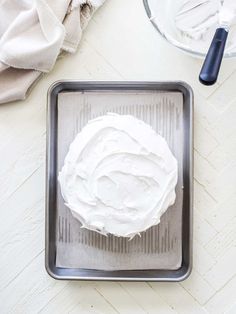 a pan with white frosting sitting on top of a table